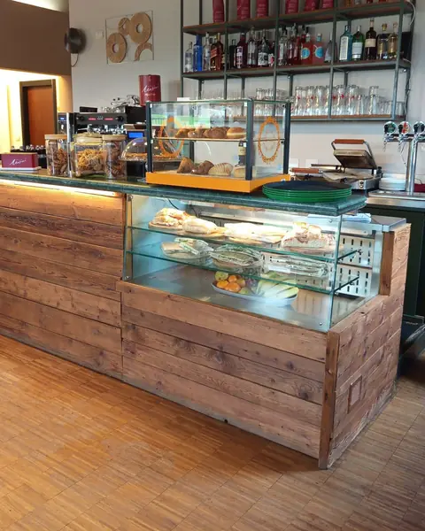 Il bancone in legno del Ristorante Bucaneve con la vetrina e lo scaffale delle bottiglie